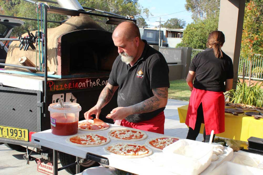 Mobile wood-fired pizza chef preparing fresh pizzas for a kids’ birthday pizza catering event in Sydney.