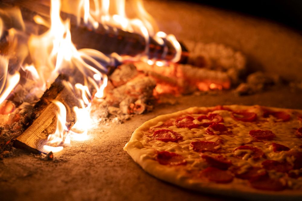 Woodfired mobile catering setup with pizza oven at outdoor event